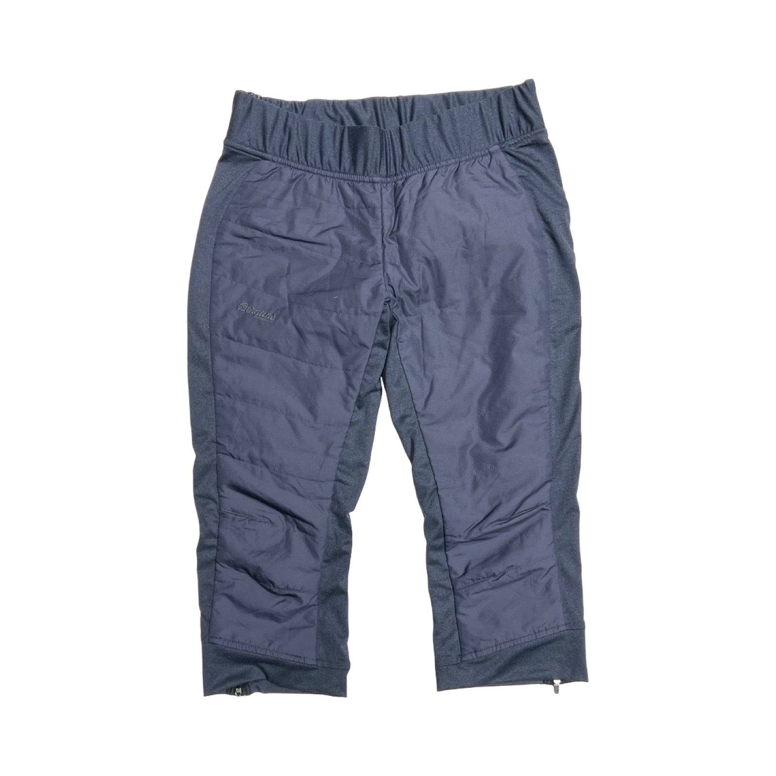 Bergans Stranda Hybrid 3/4 funktionsbyxa för dam i blått. Byxan är fotograferad platt framifrån mot en vit bakgrund.