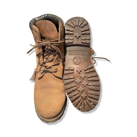 Timberland-kängor för dam i brunt, där ena kängan visas framifrån och den andra visar sulan. Fotograferade mot en vit bakgrund.