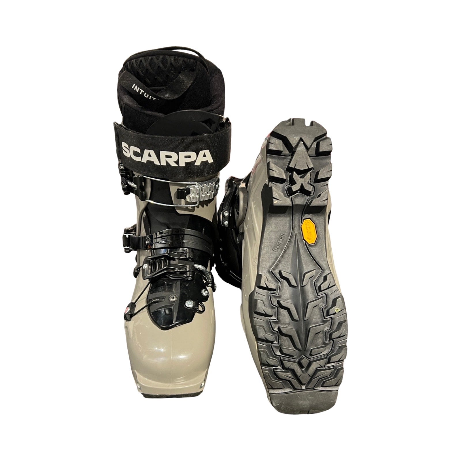 Pjäxor Scarpa Maestrale Tactical 270 för herr i ljusgrått och svart, fotograferade mot en vit bakgrund. En pjäxa visas framifrån och den andra visar Vibram-sulan.