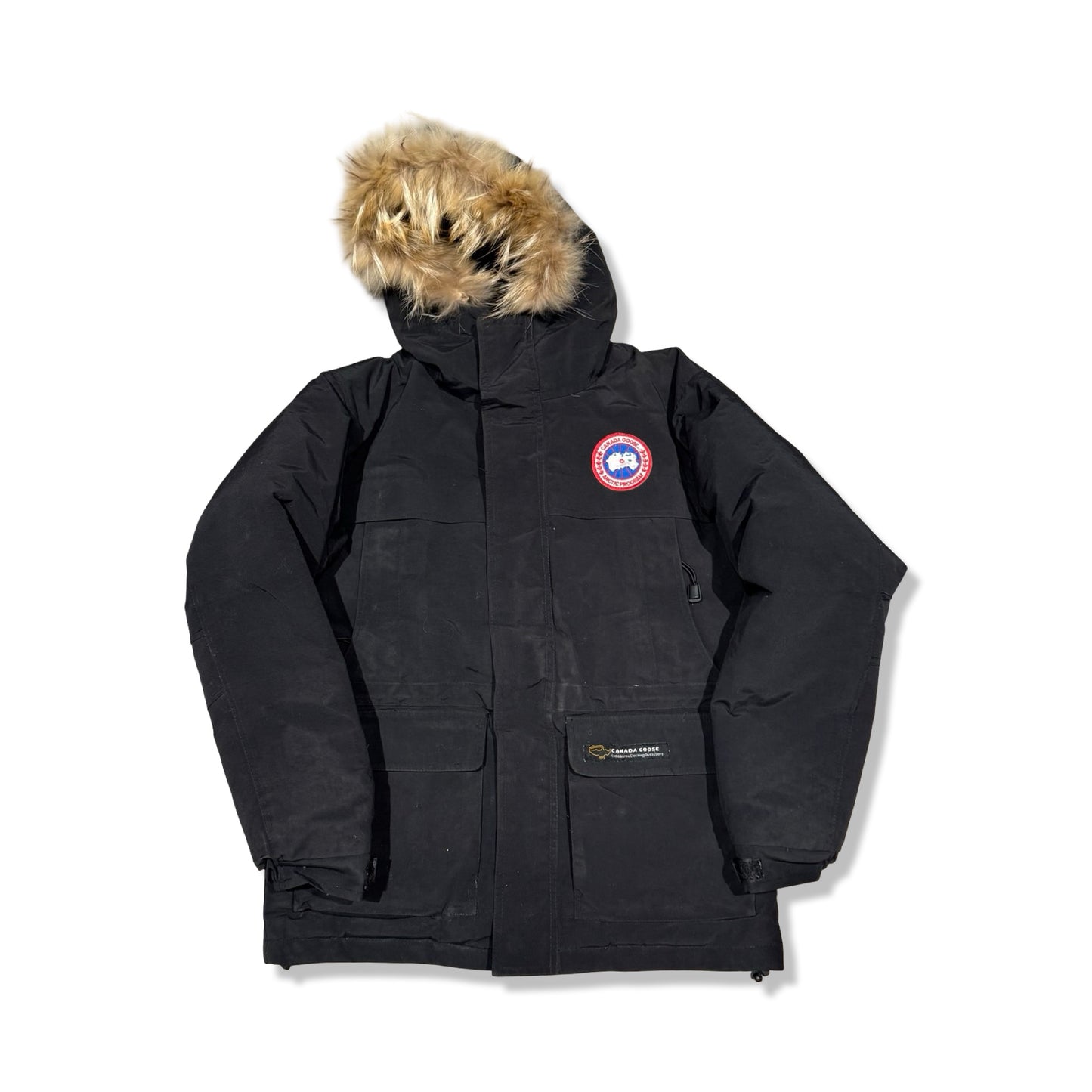 Canada Goose parkas för barn i svart. Jackan har en huva med pälskant och är fotograferad framifrån mot en vit bakgrund.