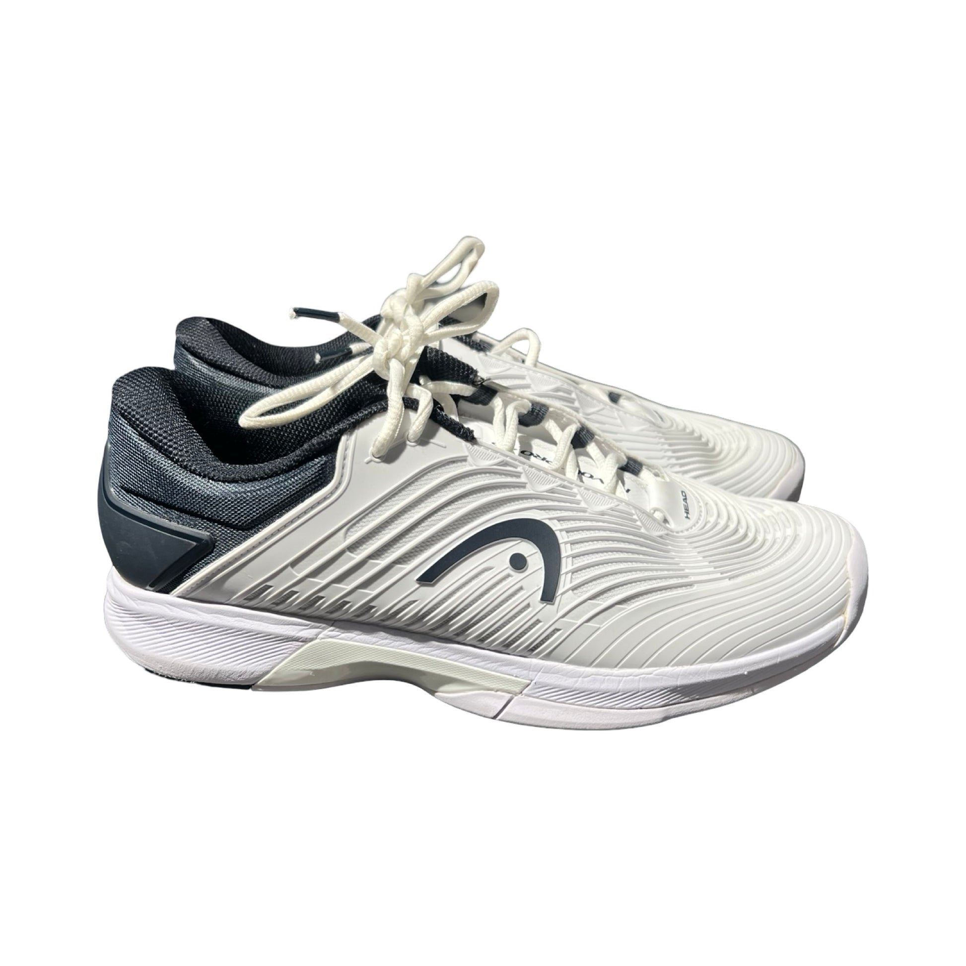 Träningsskor Head Revolt 4.5 för herr i vitt och mörkgrått. Skorna visas från sidan mot en vit bakgrund.