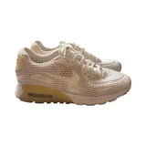 Nike Air Max 90 Ultra Breathe-sneakers för dam i beige och vitt, fotograferade från sidan mot en vit bakgrund.