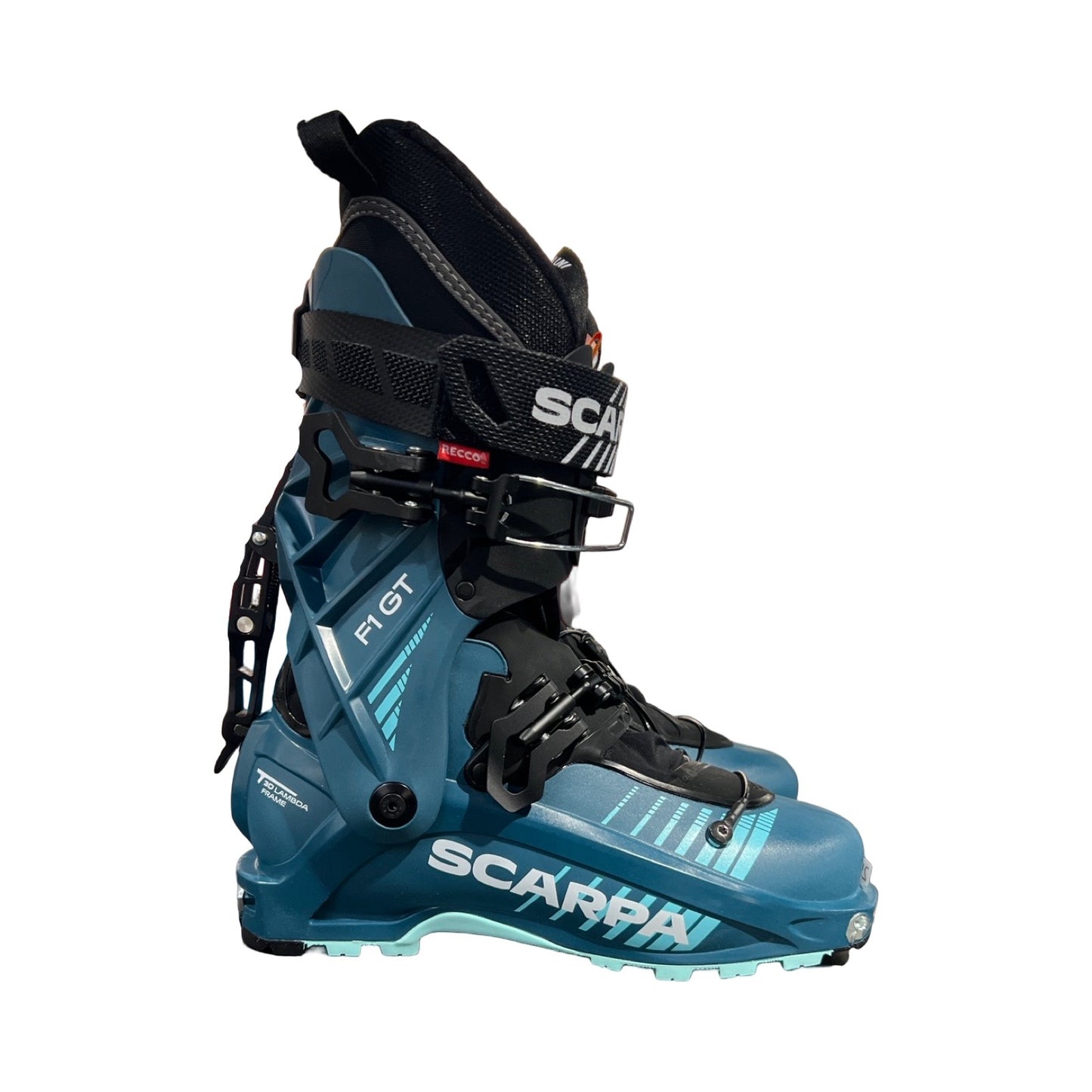 Pjäxor Scarpa F1 GT för dam i turkos och svart, fotograferade från sidan mot en vit bakgrund.