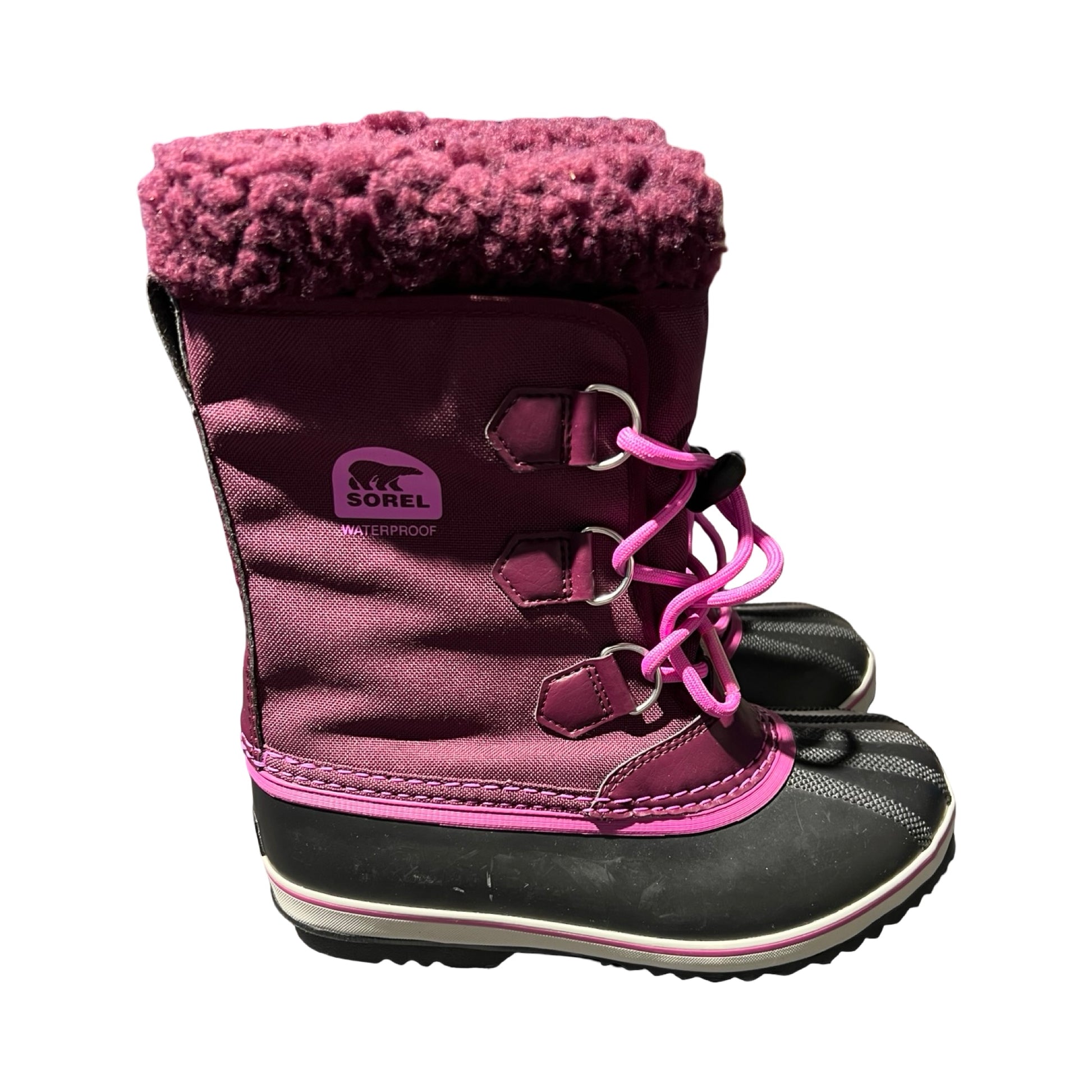 Sorel Yoot vinterkängor för barn i lila och svart med rosa detaljer, fotograferade från sidan mot en vit bakgrund.