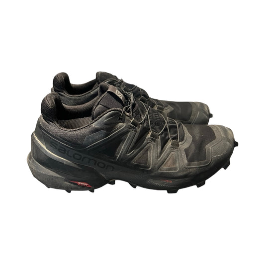 Ett par svarta Salomon Cross träningsskor för herr, fotograferade från sidan mot en vit bakgrund.