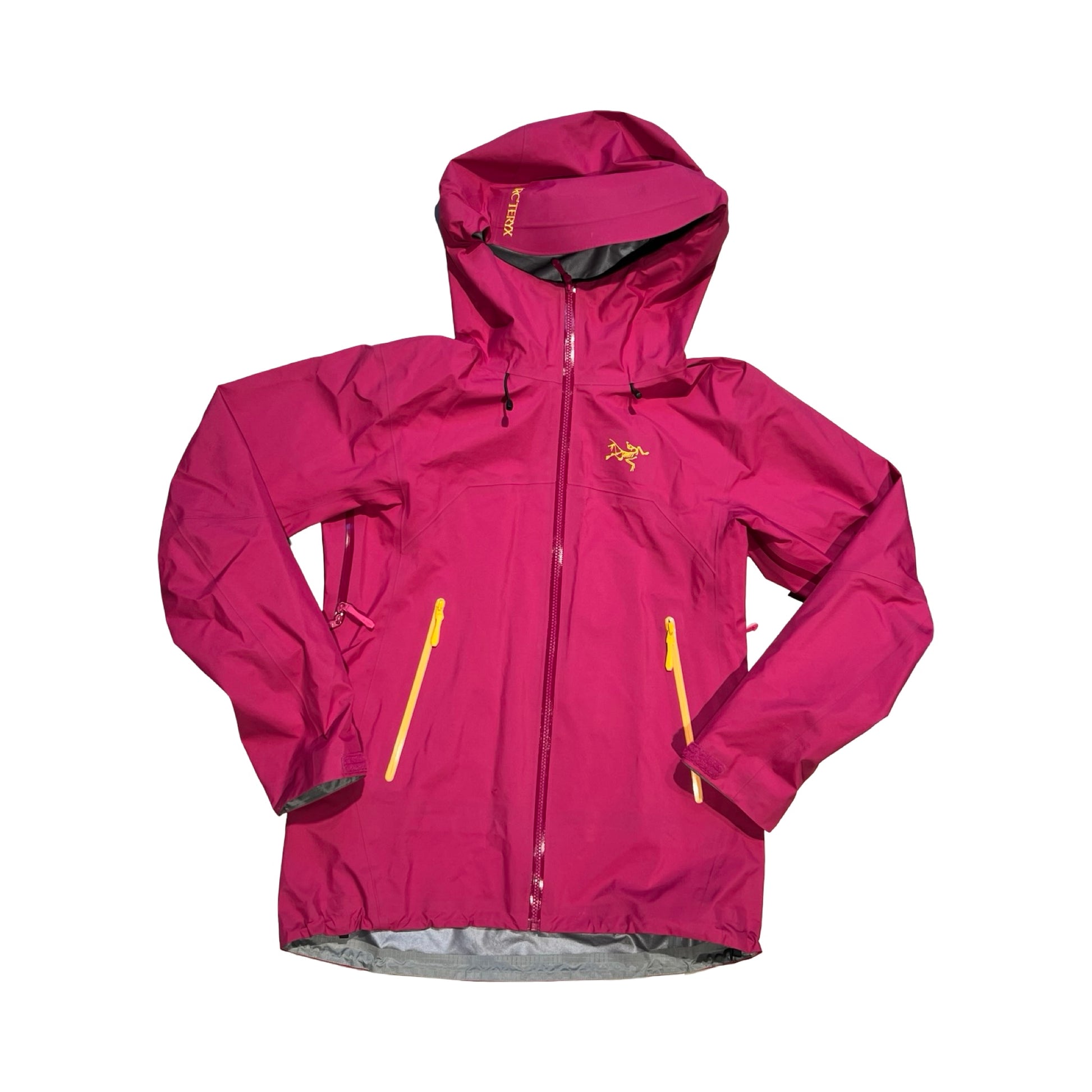 Arc'teryx Beta skaljacka för dam i rosa. Jackan har huva och heldragen dragkedja med gula detaljer och är fotograferad platt framifrån mot en vit bakgrund.