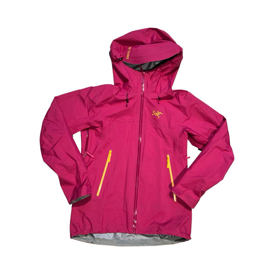 Arc'teryx Beta skaljacka för dam i rosa. Jackan har huva och heldragen dragkedja med gula detaljer och är fotograferad platt framifrån mot en vit bakgrund.