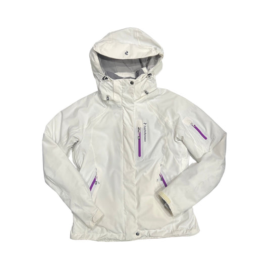 Peak Performance Solitude skidjacka för dam i vitt med lila detaljer, fotograferad framifrån mot en vit bakgrund.