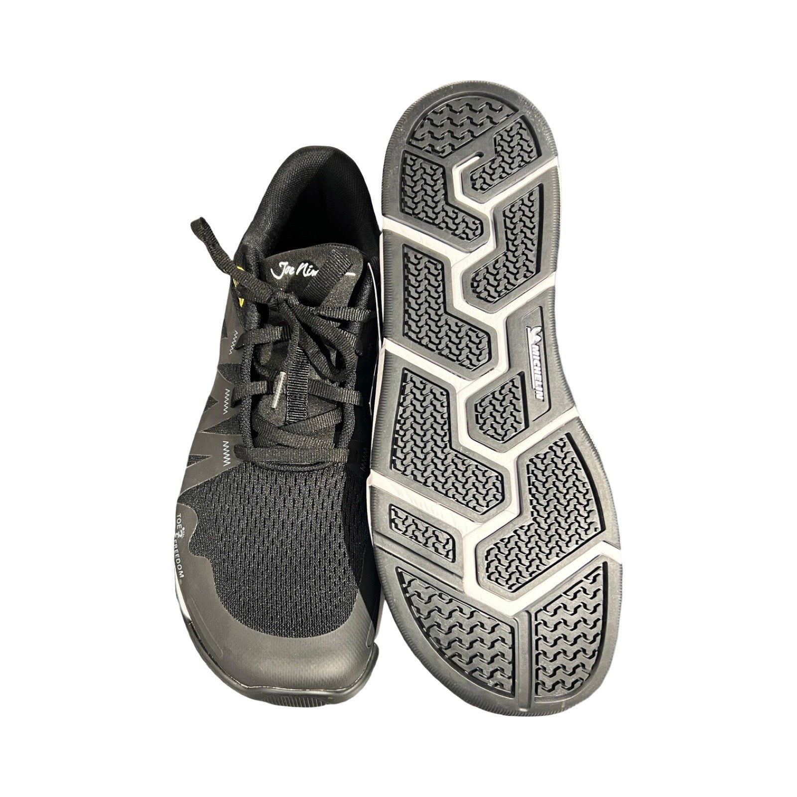 Joe Nimble Addict Road löparskor för herr i svart, där den ena skon visar ovansidan och den andra visar undersulan. Fotograferade platt mot vit bakgrund.