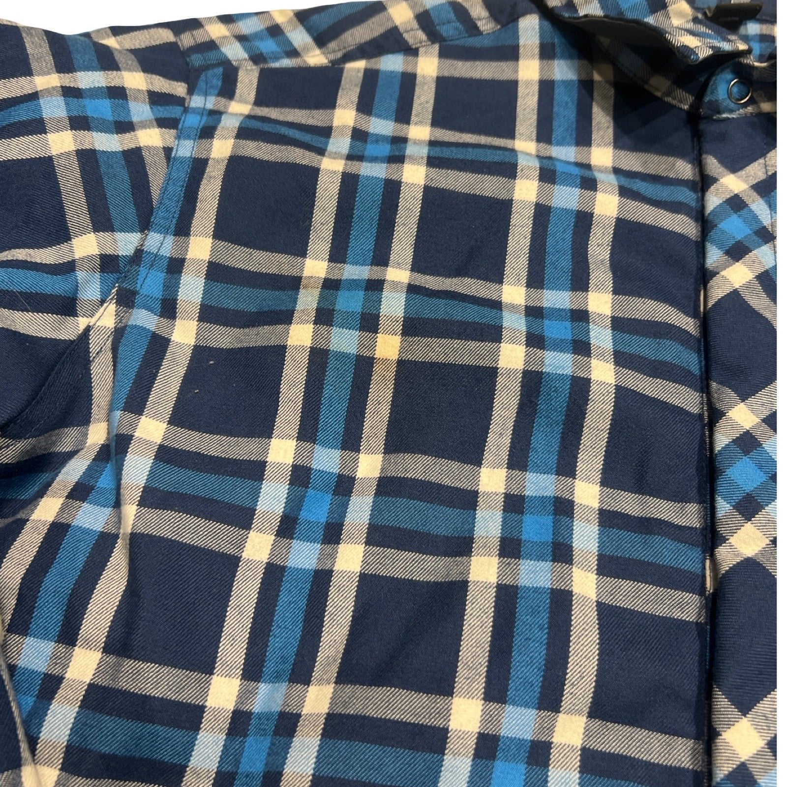 Närbild på det blå- och vitrutiga tyget på syntetjackan Haglöfs Tundra för herr.