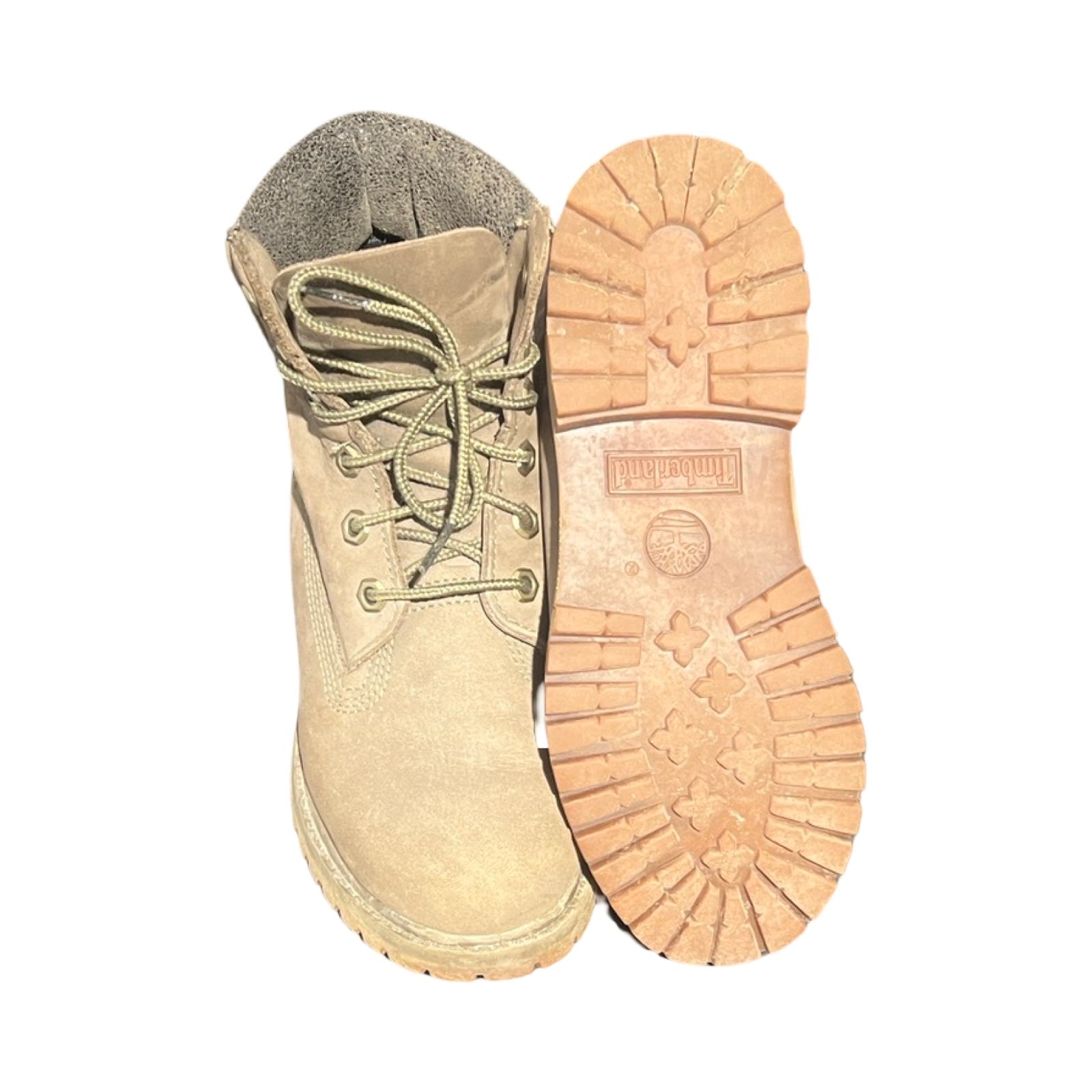 Timberland-kängor för dam i beige, fotograferade mot en vit bakgrund. Den ena kängan visas framifrån och den andra visar sulan.