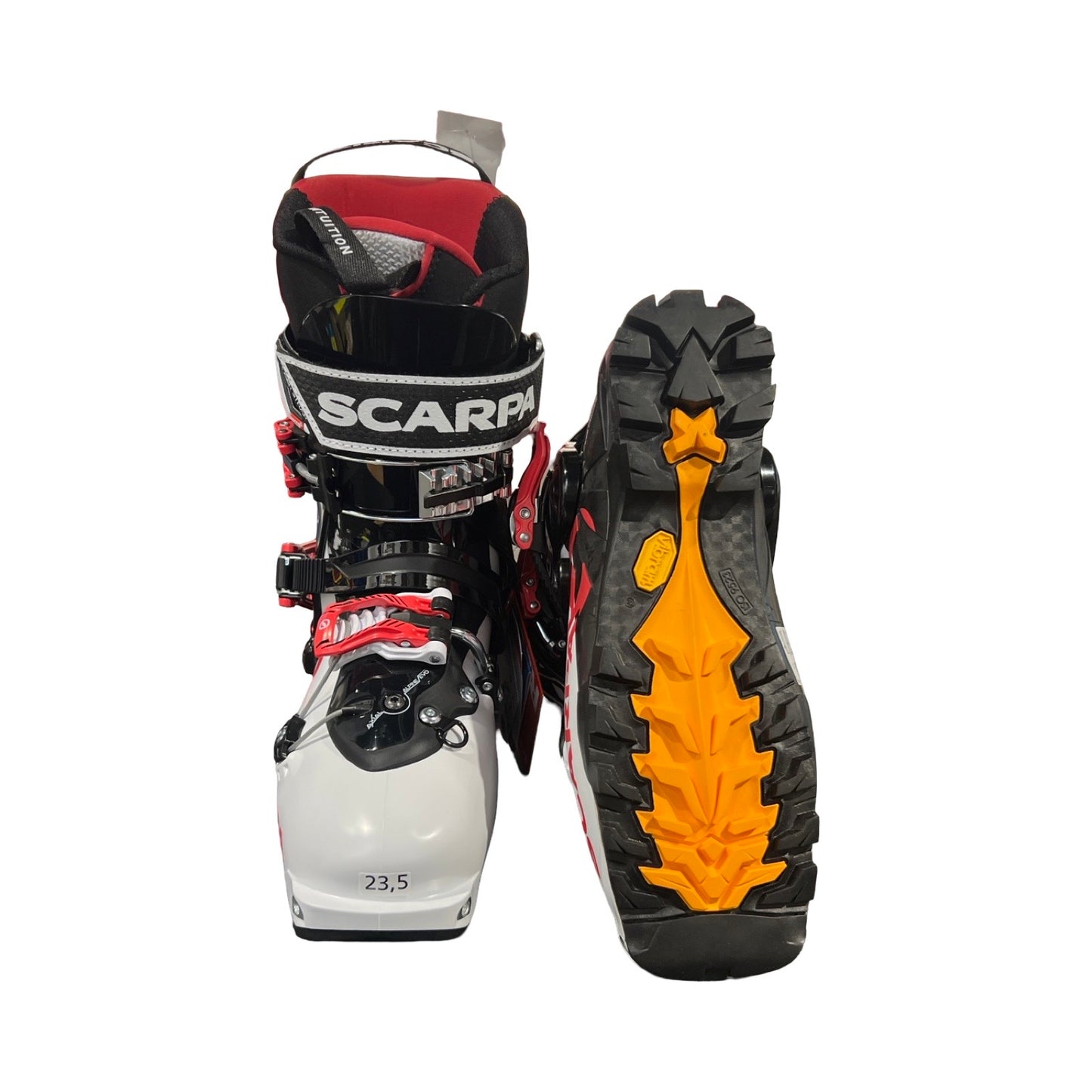 Scarpa GEA RS pjäxor för dam i vitt, rött och svart, fotograferade mot en vit bakgrund. En pjäxa visas framifrån och den andra visar sulan.