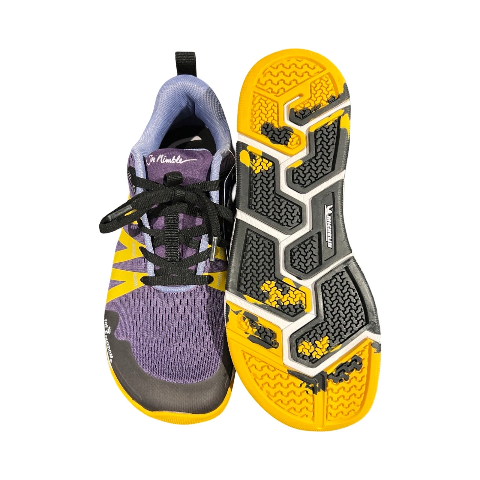 Joe Nimble Road Addict löparskor för dam i lila med gula detaljer, fotograferade ovanifrån mot en vit bakgrund. Ena skon visar ovansidan och den andra visar sulan.