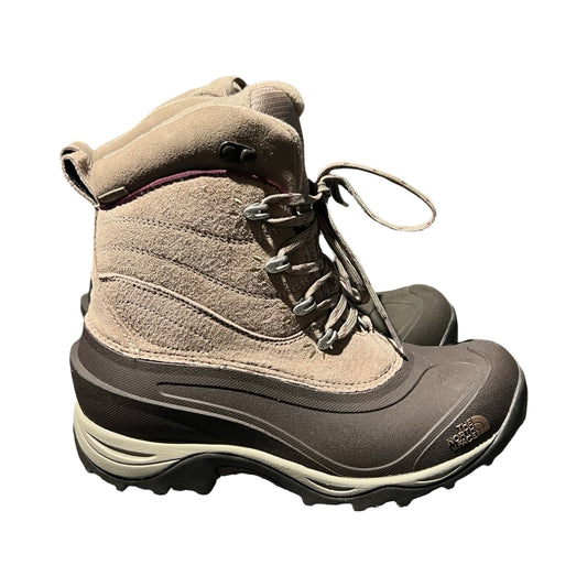 The North Face vinterkängor för dam i beige och mörkbrunt. Kängorna har ett högt skaft med snörning och är fotograferade från sidan mot en vit bakgrund.