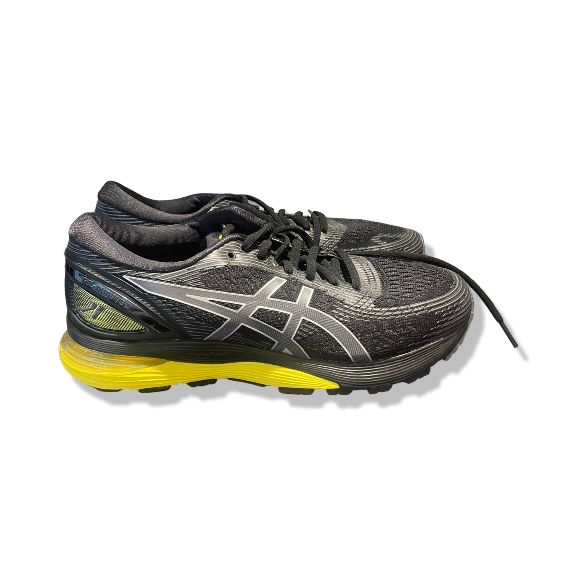 Asics GEL-Nimbus 21 löparskor i svart med gul sula och silverdetaljer, sedda från sidan mot vit bakgrund.