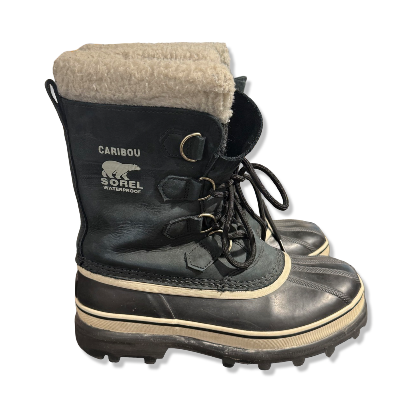 Sorel Caribou vinterkängor för dam i svart, fotograferade från sidan mot en vit bakgrund.