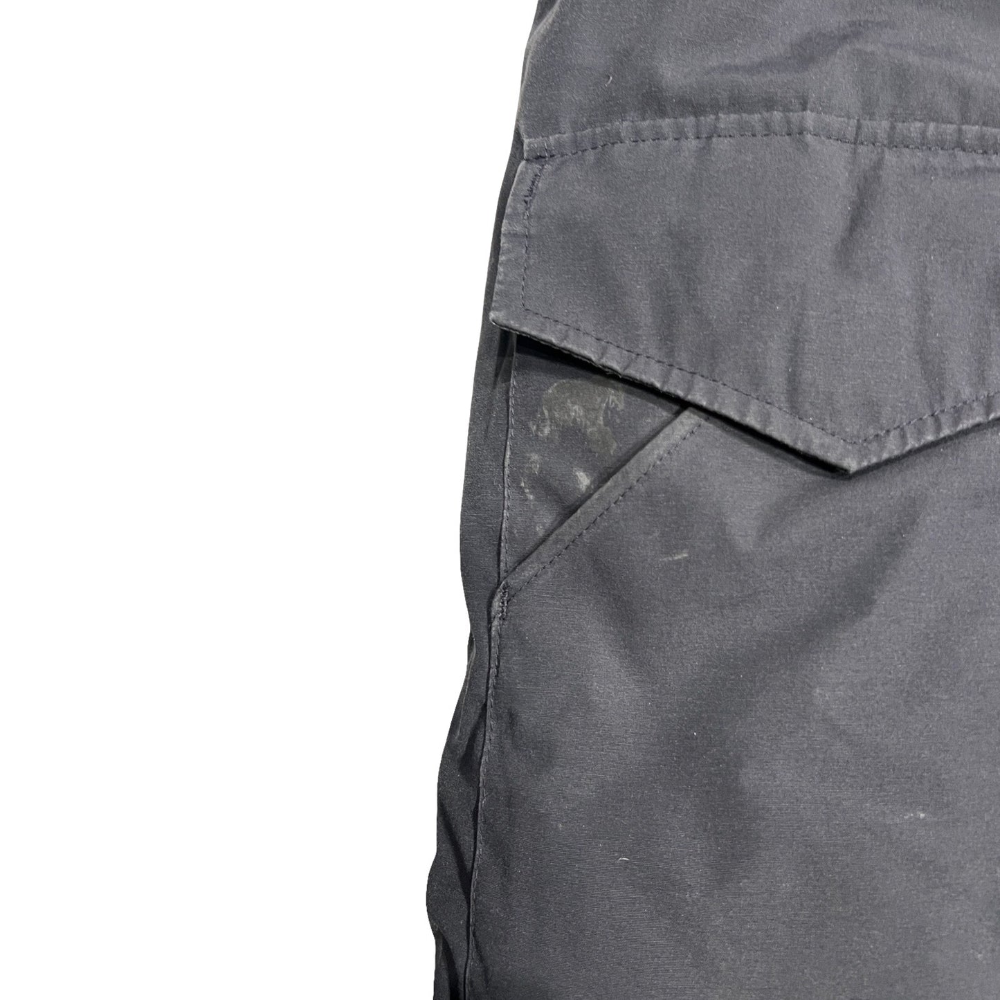 Närbild på fläckar vid fickan på Canada Goose Heli Arctic dunjacka för herr i svart.