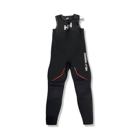 Svart Helly Hansen Blockline Salopette våtdräkt i neopren för barn, fotograferad framifrån mot vit bakgrund.