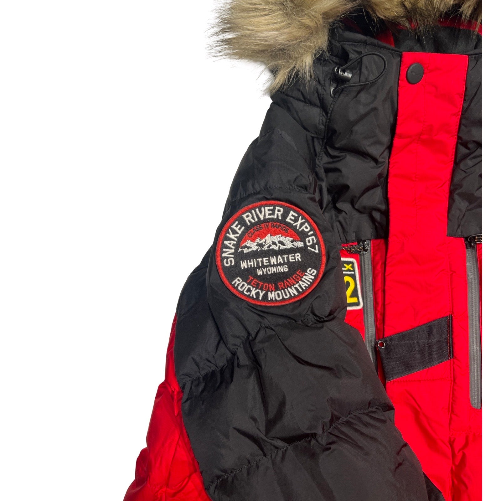 Närbild på ett märke på ärmen på en röd och svart Parkas RLX Transglobal Expedition för herr.