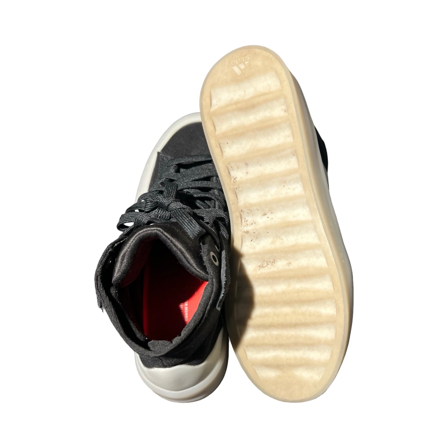 Svarta höga sneakers från Adidas för dam, fotograferade uppifrån mot vit bakgrund. Ena skon visar den ljusa undersulan.