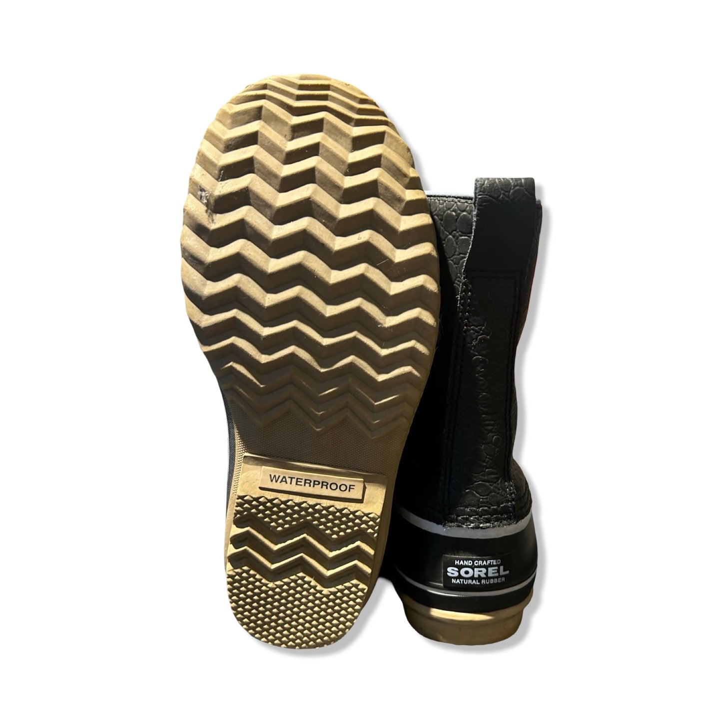 Baksidan och sulan på ett par svarta Sorel Premium vinterkängor för dam, fotograferade mot en vit bakgrund.