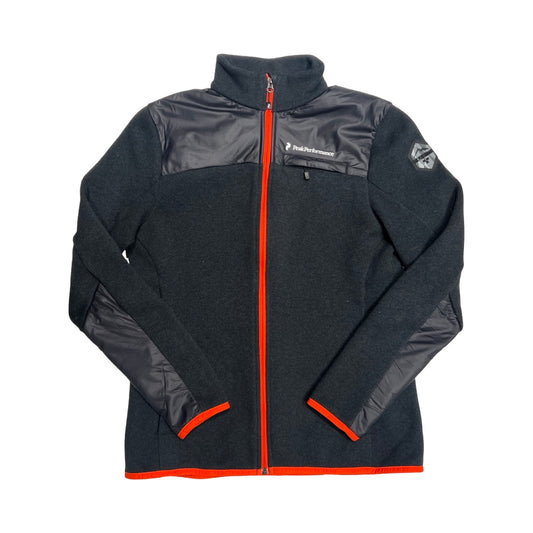 Peak Performance Tebulos fleecetröja för dam i mörkgrått med orangea detaljer. Tröjan har hög krage och heldragen dragkedja och är fotograferad platt mot en vit bakgrund.